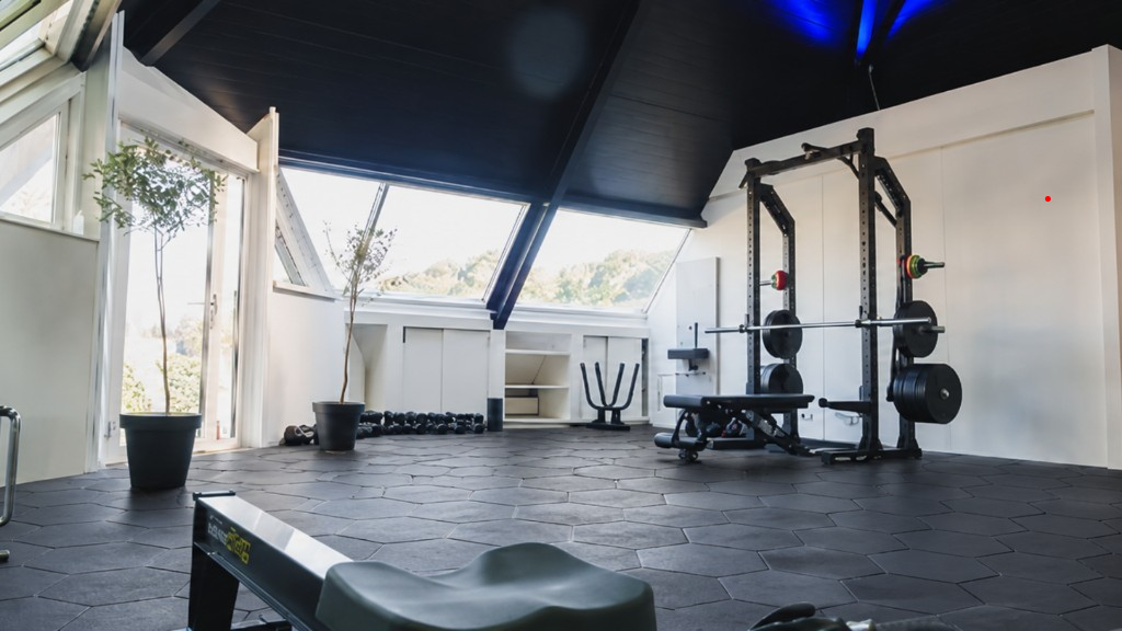 Superstrata Hex black hexagon tiles installed in a commercial gym with free weights and natural light
